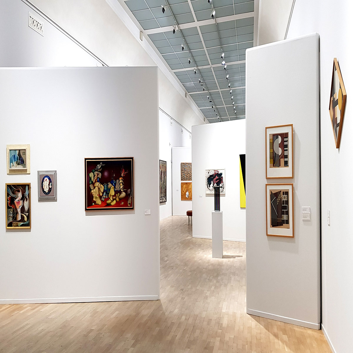 Foto som föreställer galleri 2 på Konstmuseet med tavlor som hänger på väggarna och en skulptur på ett podium.