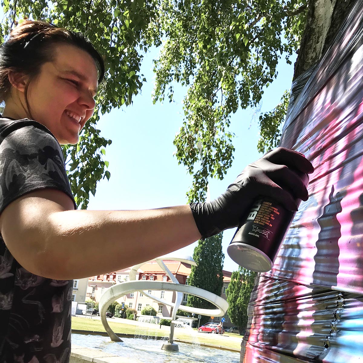 En glad tjej målar graffiti.